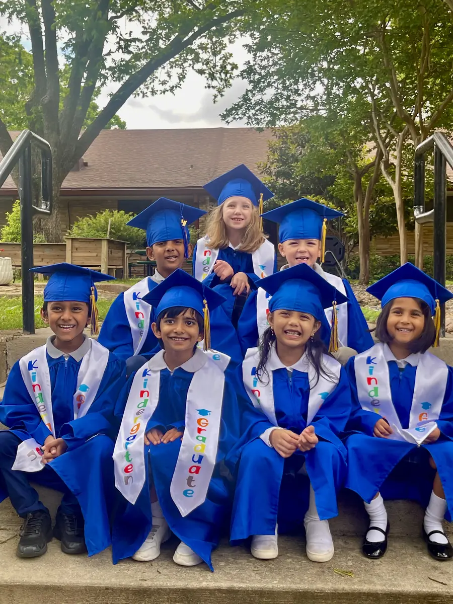 Kindergarten graduates in blue caps and gowns